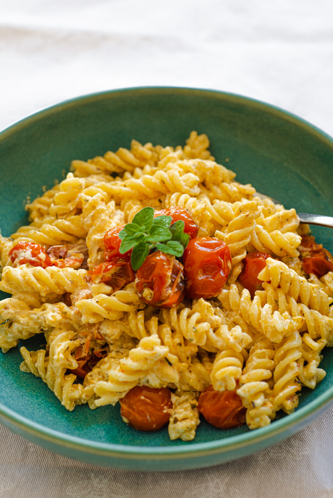 baked Feta cheese and Cherry tomatoes with fusilli pasta served on a plate