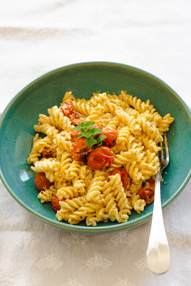 baked Feta cheese and Cherry tomatoes with fusilli pasta served on a plate