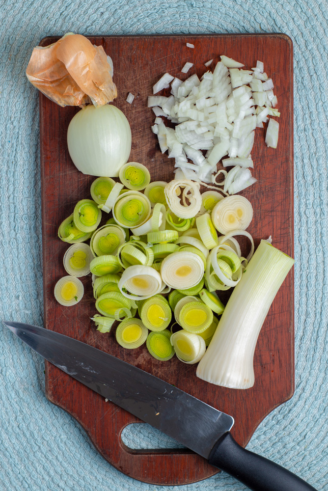 chopped leeks and onions on a chopping board