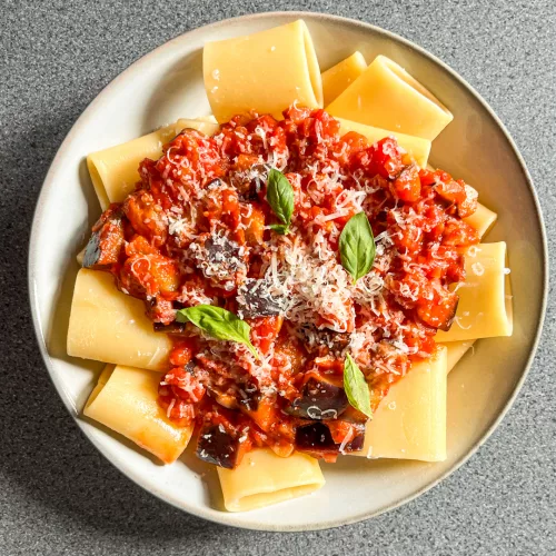 top view of a bowl of paccheri pasta with eggplant and tomato sauce
