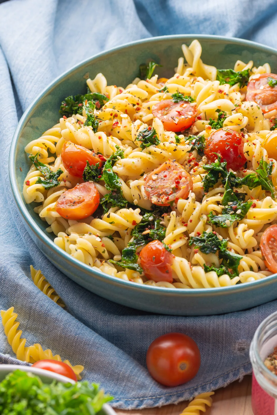 top view of a bowl with cherry tomatoes and kale fusilli pasta