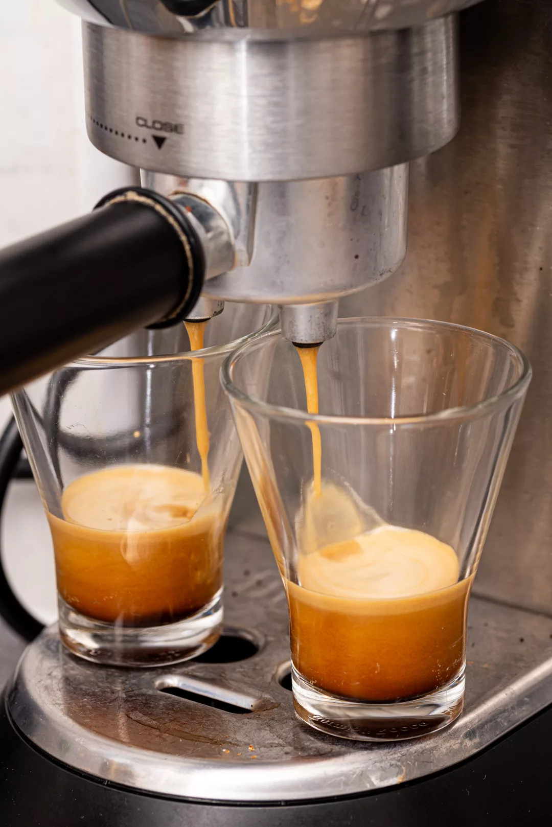 espresso machine pouring two shots of espresso into two mugs