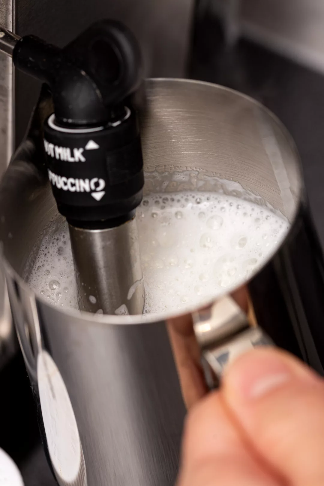 milk frothing through the nozzle of an espresso machine