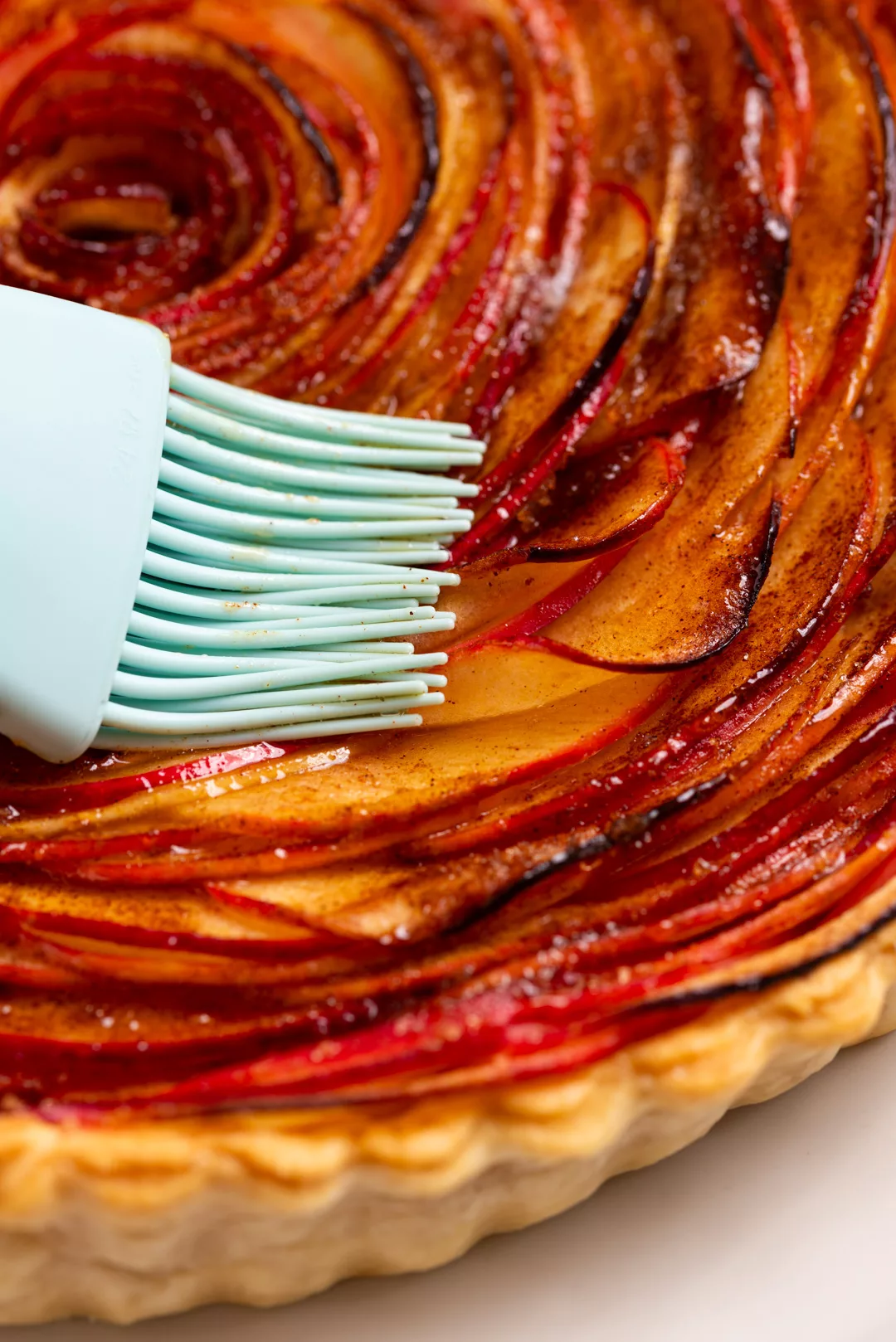 apple rose tart close up with a pastry brush